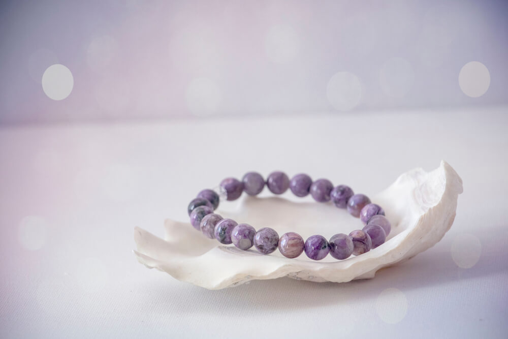 bijoux en cristaux violet posé sur un coquillage