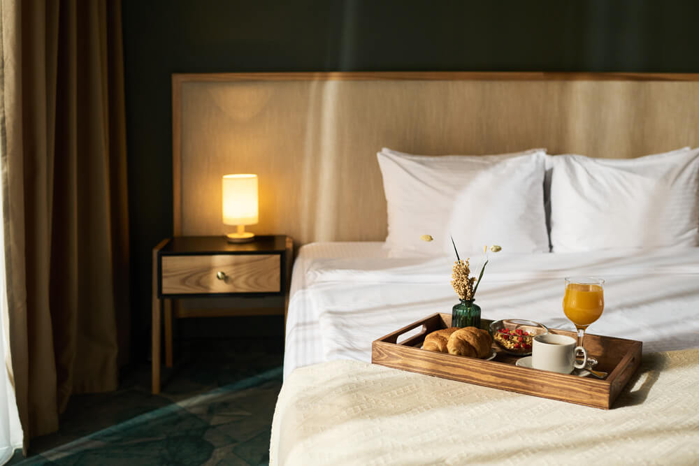 chambre d'hôtel au style cosy, avec un plateau repas posé sur le lit