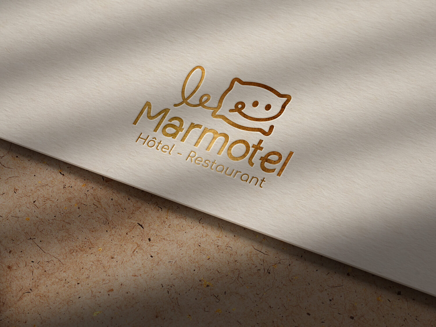 logo du marmotel en mode or, une création d'identité visuelle par l'agence com commerce